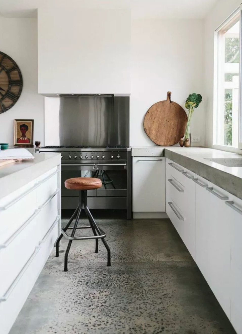 Polished Concrete Kitchen flooring with white cabinetry and wooden stools
