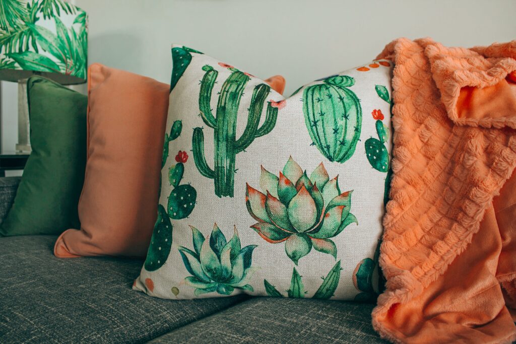 Couch with plant-patterned and orange pillows