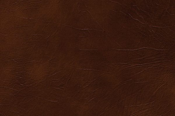 Close-up of Genova Chocolate leather showing dark brown color, visible creases, and natural grain patterns for a slightly worn, rugged look.