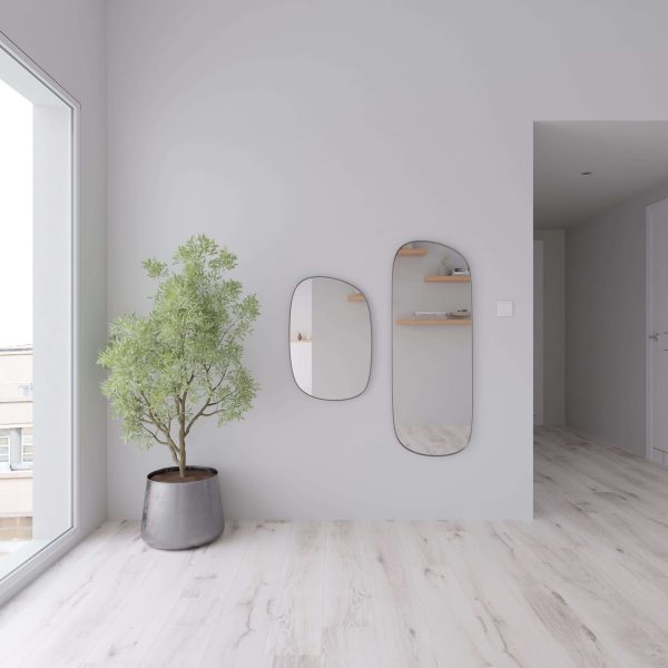A minimalist room features Palmetto Oak floors, a potted tree, two asymmetrical mirrors on a white wall, and shelves with decor reflected in the mirrors. Natural light streams through a large window.
