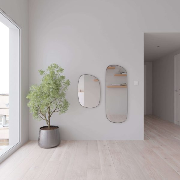 Minimalist room with River Run Oak floors, a potted green plant near a large window, and two oval mirrors on a light gray wall reflecting shelves decorated with stylish accents.