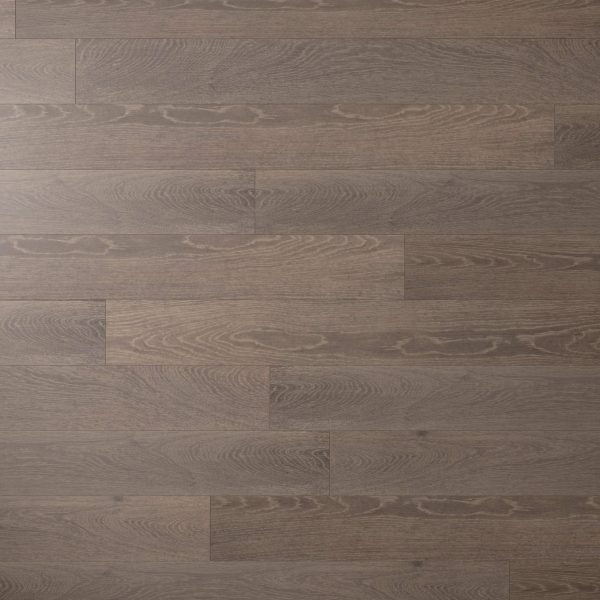 A close-up of Otter Oak* flooring shows wide, rectangular planks in a staggered layout. The smooth surface features a grayish-brown hue with distinct wood grain patterns.