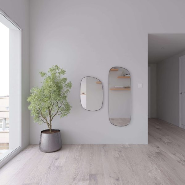 Minimalist room with Eaglecrest Oak floors, a potted green plant by a large window, and two oval mirrors on a white wall. Shelves with a few items are reflected in the mirrors.