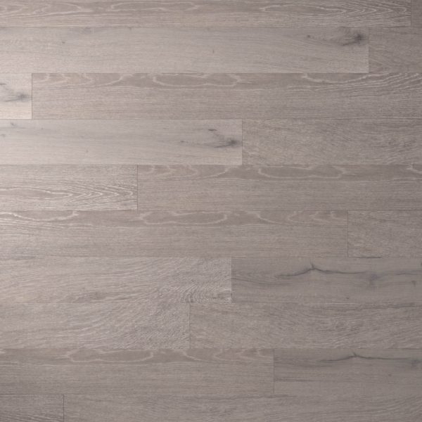Eaglecrest Oak features light gray wooden floorboards arranged horizontally, showcasing subtle wood grain patterns, natural texture, a smooth matte finish, and occasional darker streaks and knots.