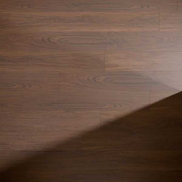 The Adirondack Oak floor features a smooth, dark brown finish with visible grain patterns. A shadow falls diagonally across the lower right corner of the flooring.