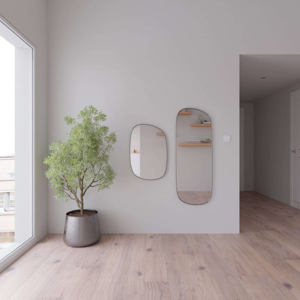A minimal room features Falcon Oak flooring, light gray walls, a large potted plant, and two oval mirrors. Decor items are visible on shelves in the mirror’s reflection, while natural light streams through a big window.