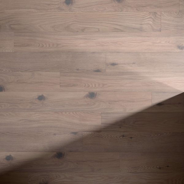 Falcon Oak light brown wooden floor features visible grain patterns and dark knots, with a diagonal shadow partially covering it from the lower right corner.