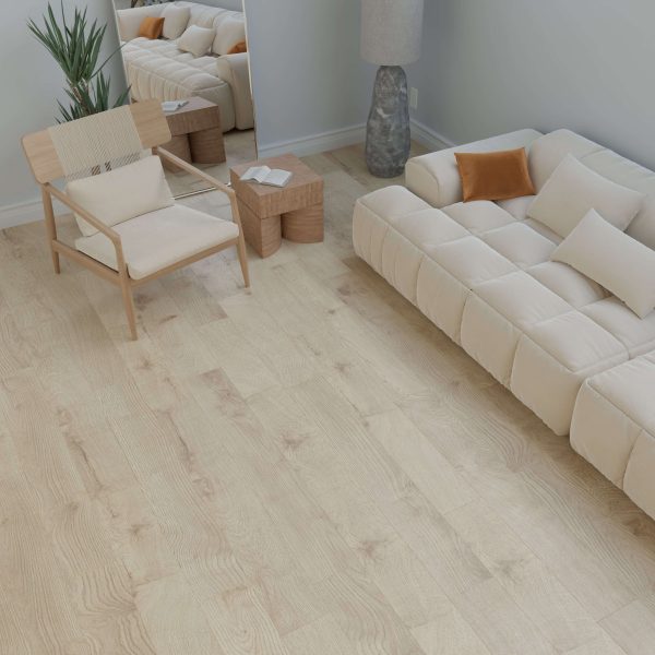 Minimalist living room featuring the Helen cream-colored couch with throw pillows, light wood flooring, a wooden chair, two small woven tables, a large mirror, tall lamp, and a potted plant in the corner.