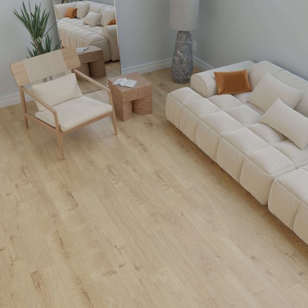 A modern living room featuring the Moraine beige tufted sofa with white and orange pillows, light wood flooring, a wooden chair with a woven seat, a tall plant, a lamp, and a mirror reflecting the furniture.