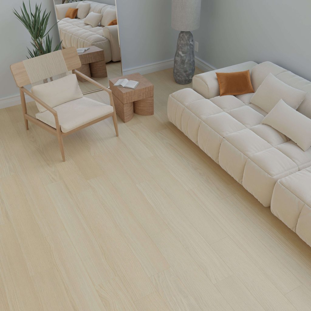 A modern living room featuring the Agnes cream-colored sofa with beige and brown pillows, light wood flooring, a wooden chair, small side tables, a tall floor lamp, a green plant, and a large mirror against a light gray wall.