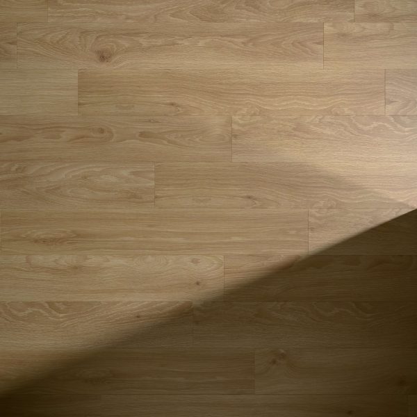 Minnewanka features a light brown wooden floor with a natural grain pattern. A diagonal shadow crosses the lower right corner, adding contrast to the otherwise evenly lit surface.