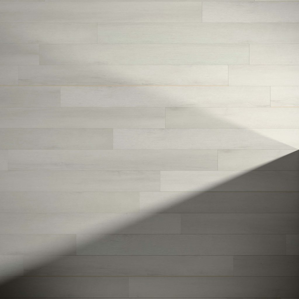 A wall or floor made of Glenbrook* light-colored wooden planks with a large, soft triangular shadow cast across the bottom right corner.