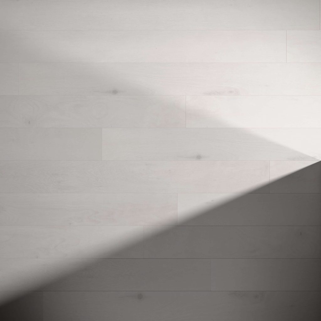 The Harmac light gray wooden flooring features wide planks with highlighted wood grain and subtle knots, partially covered by diagonal shadows that create a striking contrast between illuminated and shaded areas.