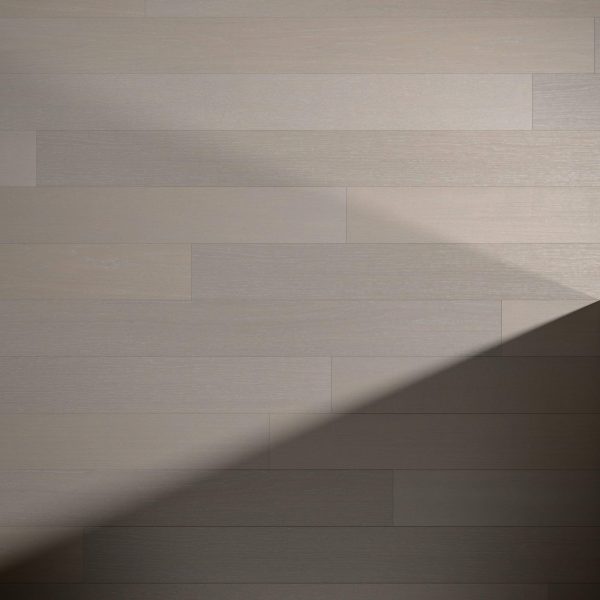Light and shadow play across Castle Rock Oak* light gray wooden planks arranged horizontally, forming a distinct triangular shadow in the lower right corner of the image.
