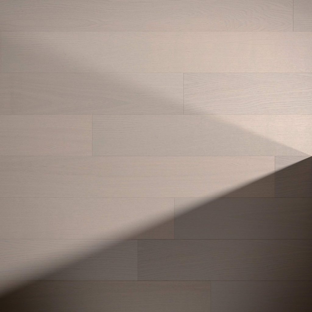 Braeburn Oak R&Q features light wooden flooring with smooth, wide planks. A diagonal shadow in the lower right creates a striking contrast between sunlit and shaded areas.