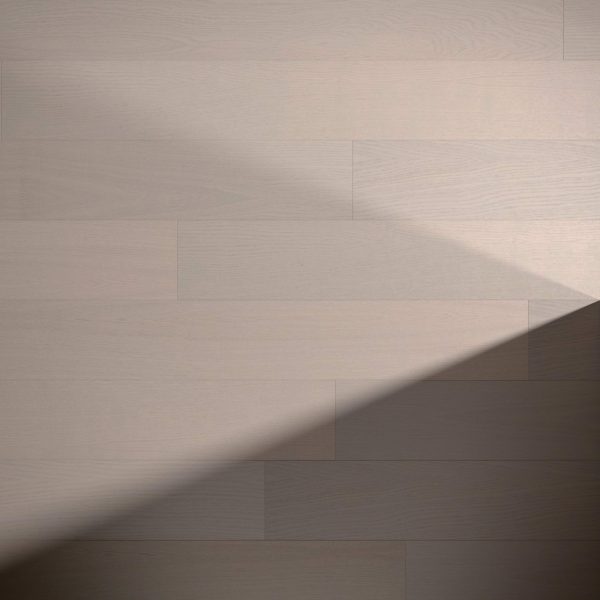 Braeburn Oak R&Q features light wooden flooring with smooth, wide planks. A diagonal shadow in the lower right creates a striking contrast between sunlit and shaded areas.