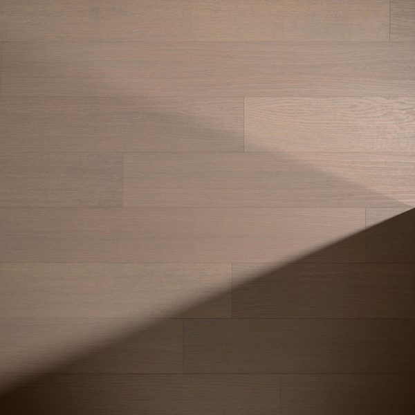 Solano Oak R&Q* features light brown, narrow wooden planks. Sunlight casts a sharp, triangular shadow across the lower right, highlighting a striking contrast between illuminated and shaded areas on the floor.