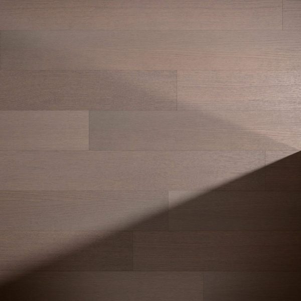 Veneto Oak R&Q floorboards feature a smooth, matte finish. A diagonal shadow falls across the brown wood panels, highlighting the contrast between lighter and darker areas.