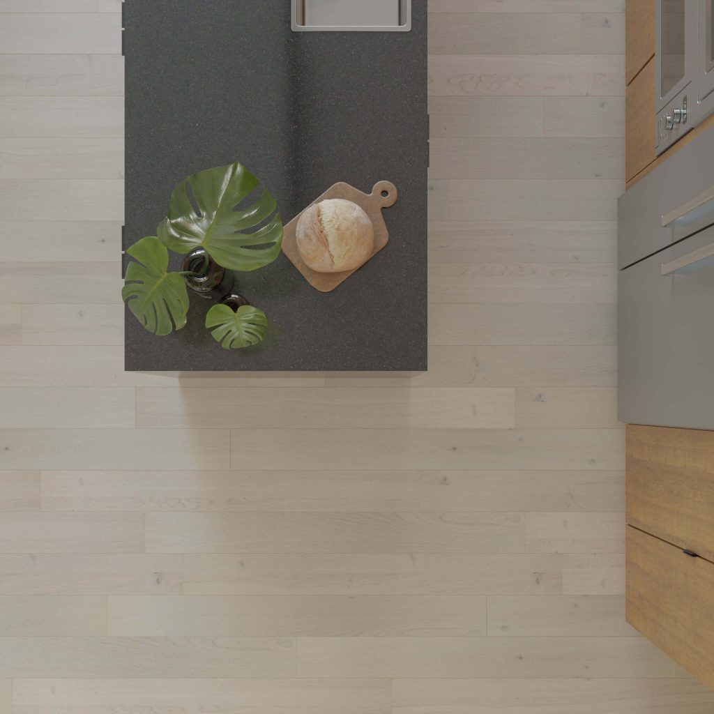 Overhead view of a modern kitchen with Crema Rustic Oak* flooring, a black countertop, a potted plant, and a loaf of bread on a wooden cutting board. Stainless steel built-in appliances complete the space.