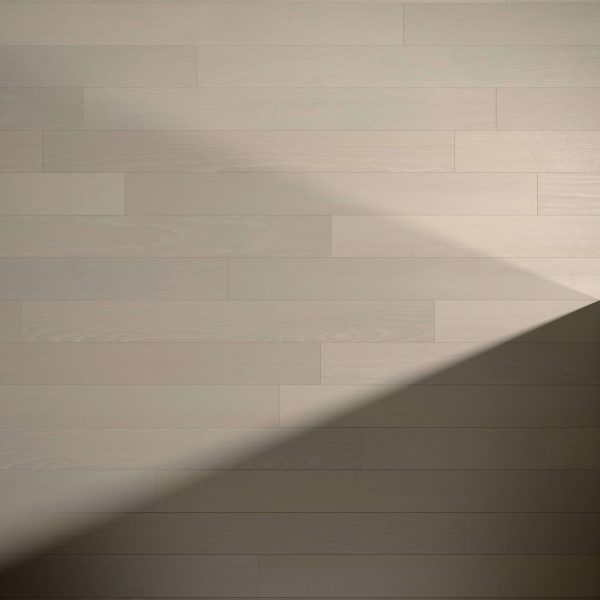 Arcadian Oak* light-colored floorboards feature a diagonal shadow, highlighting the contrast between bright and shaded areas for a minimalistic, clean look.
