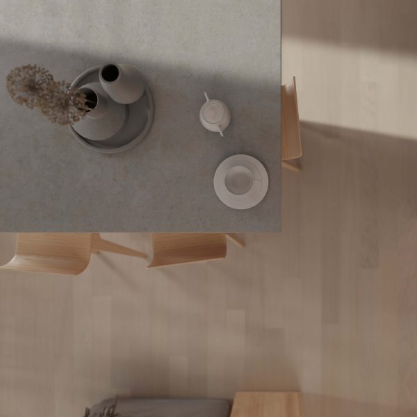Braeburn Oak* kitchen table viewed from above, with a small vase of dried flowers, teapot, cup and saucer, and wooden chairs on a light oak floor. Soft shadows and neutral colors evoke a calm, minimalist atmosphere.