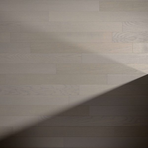 Pebble Oak* light wooden floorboards showcase a visible grain pattern. A diagonal shadow crosses the lower right, creating contrast with the lighter area in the upper left.