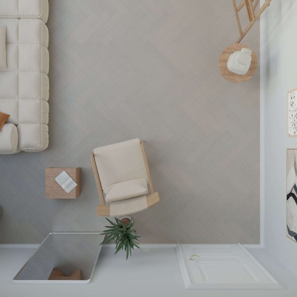 Top-down view of a minimal living room with a beige sofa, light armchair, small wooden side table, potted plant, and wall art arranged on Castle Rock Oak* (Right) herringbone-patterned flooring.