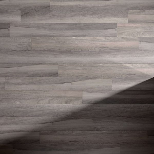 Rio Walnut* features light gray wooden floorboards with a subtle wood grain pattern. A diagonal shadow crosses the bottom right corner, highlighting the contrast between illuminated and shaded areas.