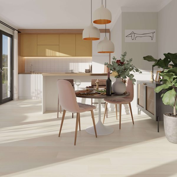 Modern dining area featuring a round table, pink chairs, plants, pendant lights, and a kitchen with Turin Oak cabinets and white tile backsplash. Sunlight streams in through large glass doors.