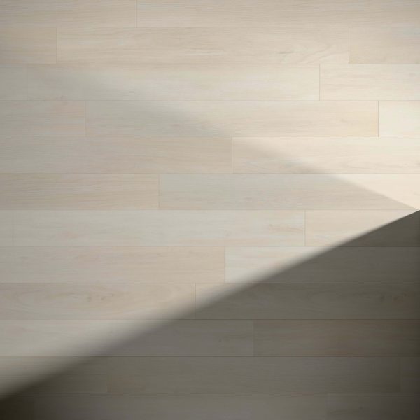 Turin Oak features wide plank, light wood flooring with a smooth, clean surface. Sunlight casts a large, angled shadow in the bottom right corner, highlighting the subtle grain patterns of the floor.