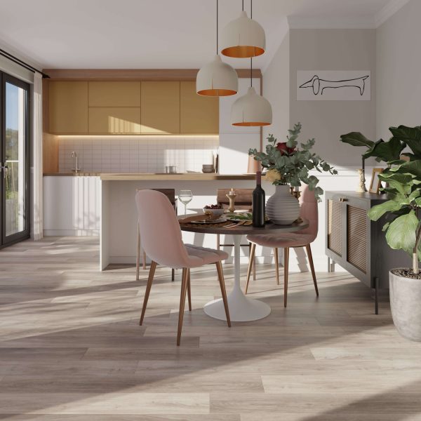 A modern kitchen and dining area features Tokyo Oak cabinets, a round table for two with pink chairs, pendant lights, indoor plants, a minimalist dog artwork on the wall, and sunlight streaming in through glass doors.
