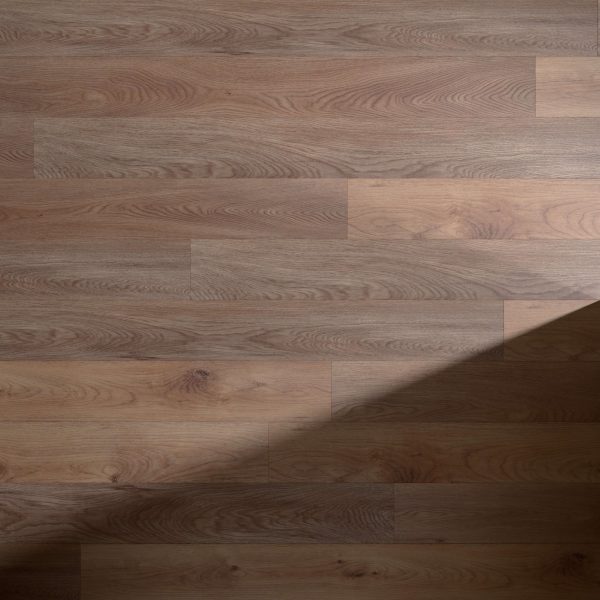 The Garros* wooden floor features natural grain patterns and knots, softly illuminated with a diagonal shadow crossing the lower right corner for added contrast on the evenly lit floorboards.