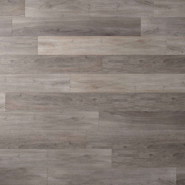 A close-up of Tokyo Oak* flooring, featuring wide planks in gray and brown tones with visible natural wood grain and subtle knots.