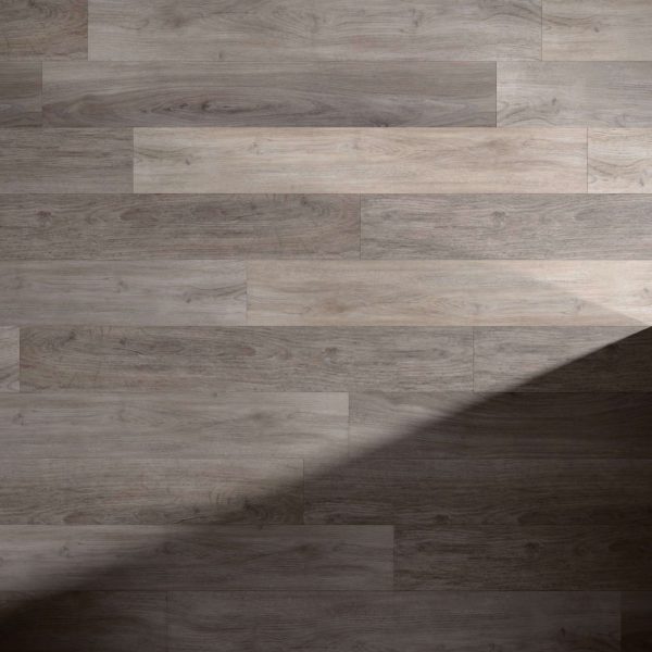 Tokyo Oak* floor planks in light gray, shown with a diagonal shadow crossing from the lower right corner, highlighting the contrast between illuminated and shaded areas.