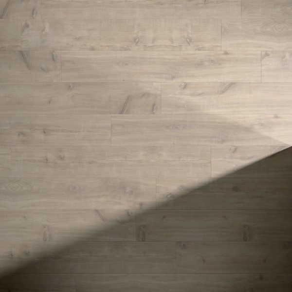 Havanna Oak Natural Saw Cut flooring, featuring a subtle grain, is partly covered by a diagonal shadow that contrasts the illuminated and shaded sections. The planks are installed in a horizontal layout.
