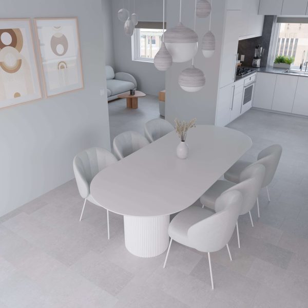 Minimalist dining room featuring an oval white table, six Metro Grey* chairs, pendant lights, modern abstract art on the wall, and an open kitchen with neutral tones in the background.