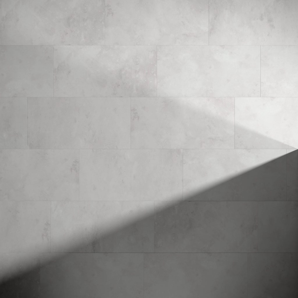 A light gray Capri* tiled wall with a diagonal shadow cast across the lower right section, creating a striking contrast between illuminated and shaded areas.