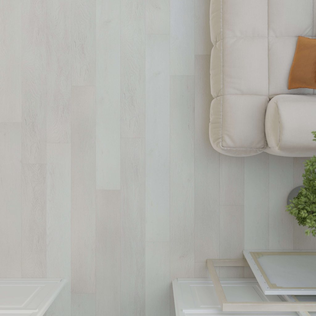 A top-down view of the Addington light wood floor, partially shown with a beige couch, orange cushion, small white table, and a green potted plant.