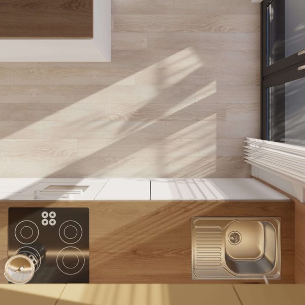 Top-down view of a modern kitchen featuring the Dakota: a black electric stovetop, stainless steel sink, and white cabinets. Sunlight from large windows casts shadows on the light wood floor.