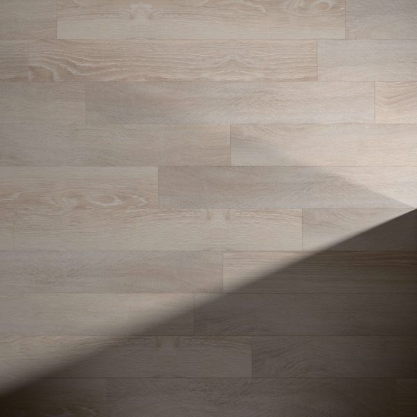 Dakota features a light-colored wooden floor with visible grain and horizontal planks. A diagonal shadow crosses the lower right, highlighting the smooth surface and creating a contrasting effect.