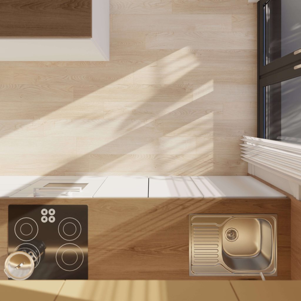 Top-down view of a modern kitchen countertop featuring the Ainsworth black electric stove, a stainless steel sink, and sunlight streaming through a window casting shadows on the light wood floor.