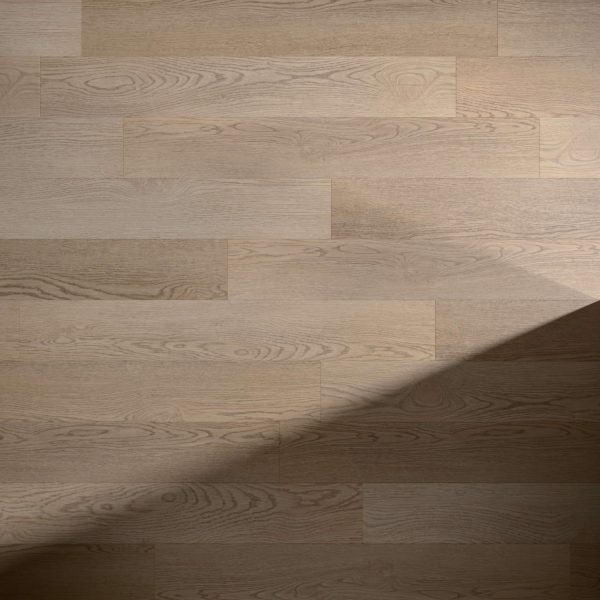 Thorncrest light brown wooden floor planks with natural grain patterns, partially covered by a diagonal shadow in the lower right corner.