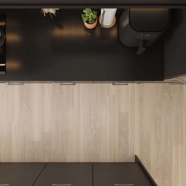 Overhead view of a modern kitchen featuring Helm Oak light wood flooring that contrasts with black countertops, a potted plant, paper towels, and an air fryer on the counter.