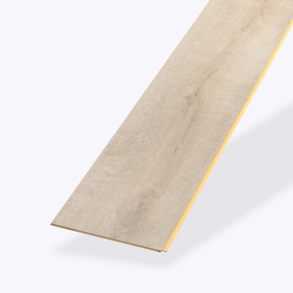 A single Badosa* vinyl flooring plank in light wood color with a subtle grain pattern is displayed on a plain background. The angled plank highlights its thin edges and one yellow groove along the side.