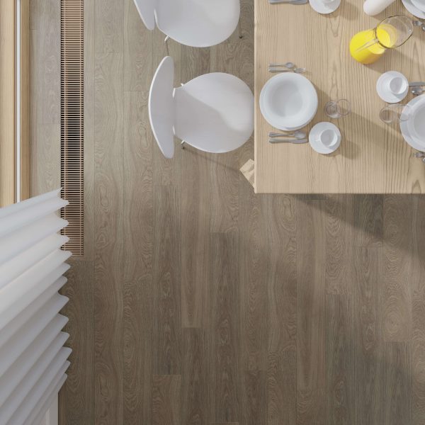 A top-down view of a Burlington Oak dining table set for breakfast with plates, cups, cutlery, and a pitcher of orange juice, next to white chairs on a wood floor by a window with white blinds.