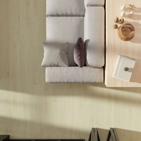 Top-down view of a light gray sofa with two pillows beside a coffee table holding decor on Galena Oak flooring. Sunlight casts soft shadows across the scene.