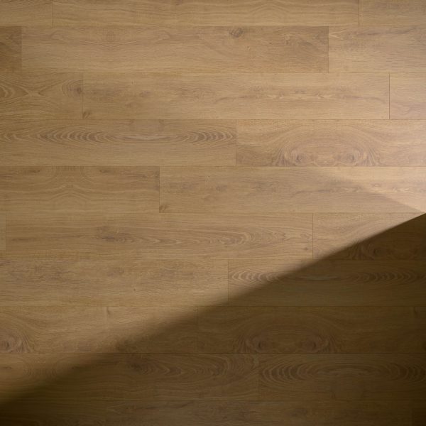 Alondra Oak light brown wooden flooring features visible wood grain patterns and knots, with a large diagonal shadow cast across the lower right corner of the image.