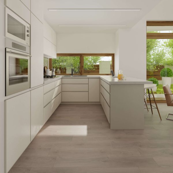 A modern, minimalist kitchen with white cabinets, built-in appliances, an island with bar stools, large windows, and light wood flooring. Green trees and natural light are visible outside.