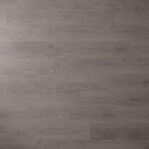 A close-up of Artesia Oak, showcasing grayish-brown planks with visible wood grain and subtle color variations. The wooden floor features a staggered plank pattern for a natural look.