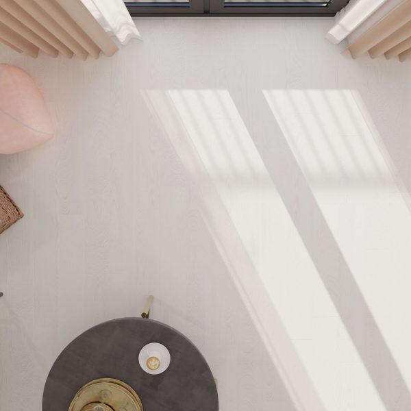 The Wenge Passionata, a round black table with a gold tray and cup, sits on a light floor by large windows. Beige curtains and part of a pink armchair appear at the edges, with sunlight casting soft shadows.